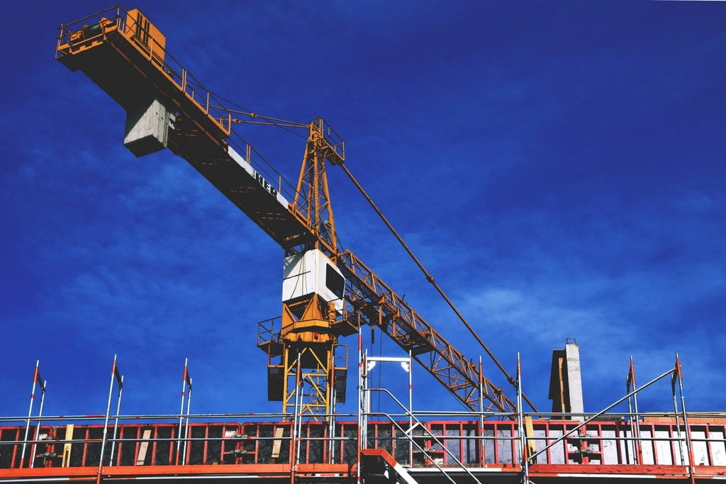 Construction cranes rising over a commercial site